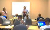 Senator Carper speaks to job seekers sitting at tables with laptops.