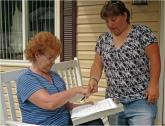 Image: Staff member conducts a survey with a community member