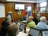 Image: A library staff member teaches visitors computer skills