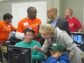 Image: Cathleen P. Black visits with a family at a computer