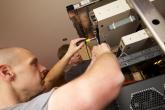 Two technicians install optical and routing equipment