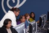 Four women learn computer basics from a Youth Policy instructor