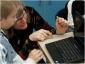 IMG: A Teacher shows a student how to get online on a netbook