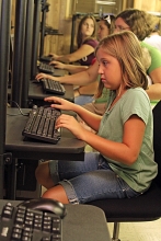 IMG: A group of children use computers at the Moorefield Computer Center