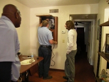 Two technicians install a SmartUnit computer kiosk into a housing unit.